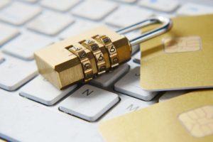 A gold padlock with a number combination lay on a white computer keyboard.